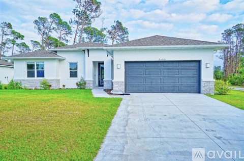 A house with a garage door and a driveway in front.