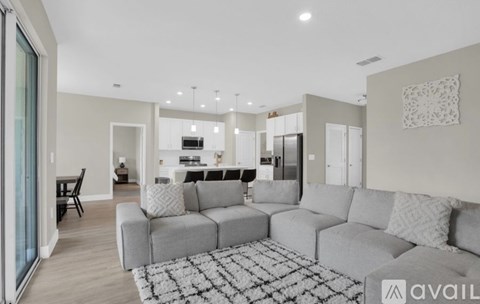A modern living room with a grey sofa and a black and white rug.