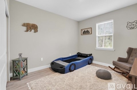 A child's bedroom with a blue bed and a bear decoration on the wall.