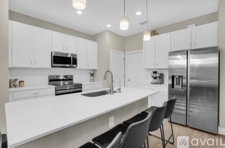 A modern kitchen with white cabinets and stainless steel appliances.