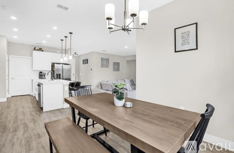 A modern kitchen with a wooden dining table and chairs.