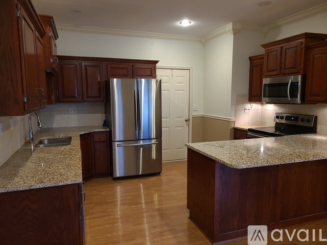 A kitchen with wooden cabinets and a granite countertop.