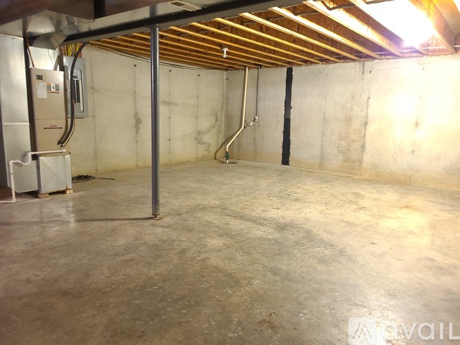 A spacious basement with concrete walls and a concrete floor.