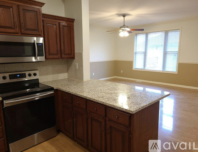A kitchen with brown cabinets and a granite countertop.