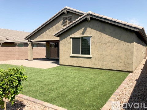A house with a brown roof and a green lawn in front.