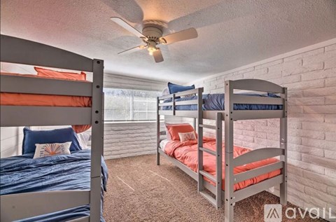 A bedroom with bunk beds and a ceiling fan.