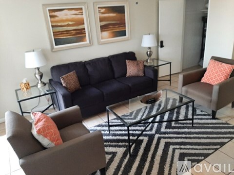 A living room with a blue couch, two chairs, and a coffee table.