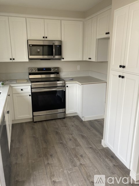 A kitchen with white cabinets and a stainless steel oven.