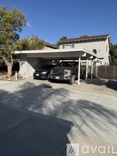A house with a garage and two cars parked in front.