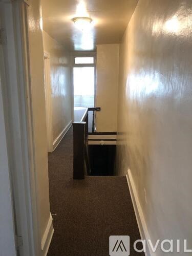 A hallway with a bench and a window.