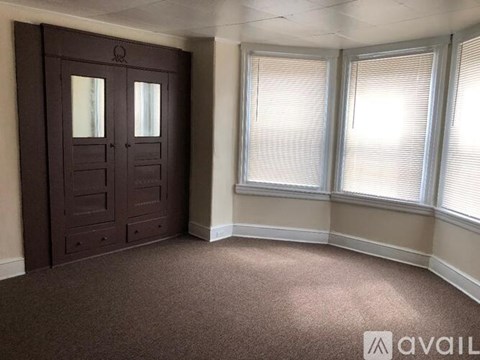 A room with a brown door and carpeted floor.