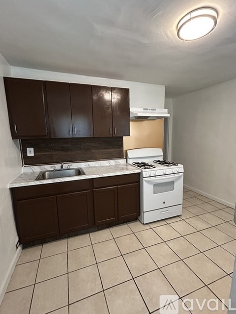 A kitchen with brown cabinets and a white stove top oven.