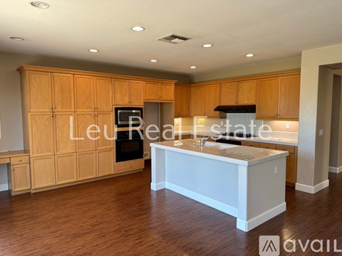 A kitchen with wooden cabinets and a white island.