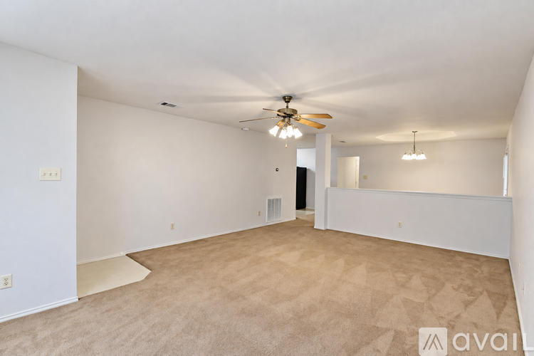 A spacious room with a ceiling fan and carpeted floor.