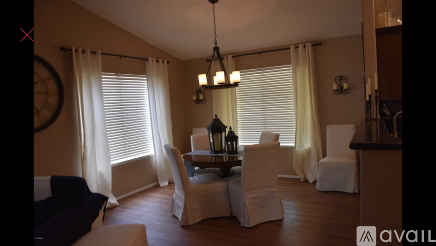 A living room with a dining table set up with chairs around it.