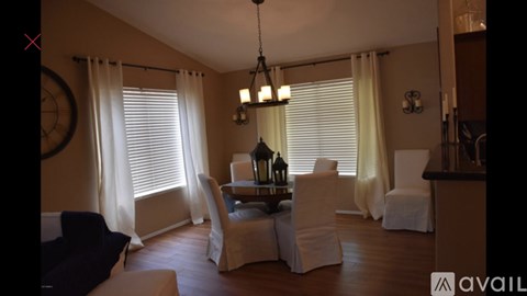 A living room with a dining table set up with chairs around it.