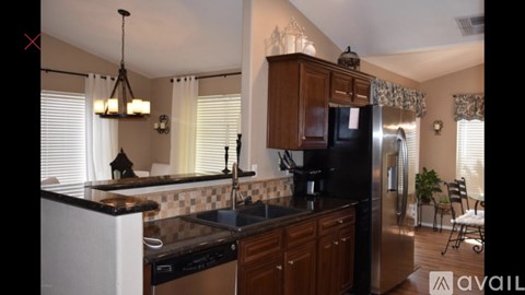 A kitchen with wooden cabinets and a black countertop.