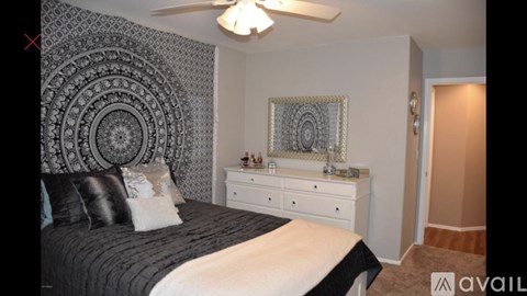 A bedroom with a bed, dresser, and mirror.