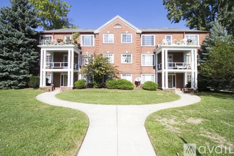 A large red brick building with a white balcony in the front.