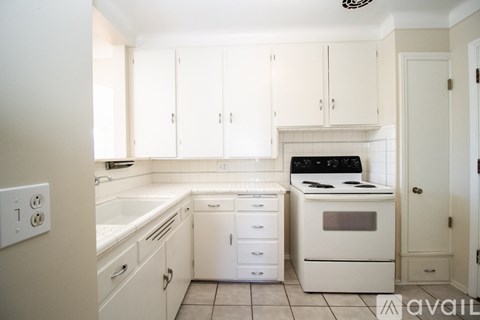 A kitchen with white cabinets and appliances.