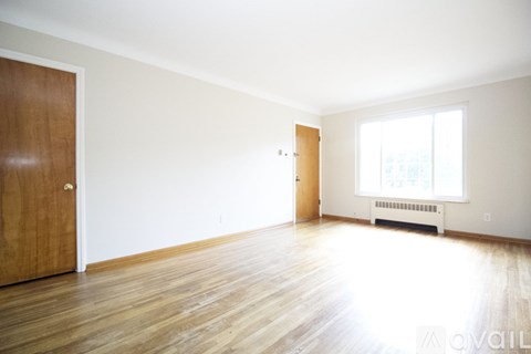 A room with wooden floors and two doors.