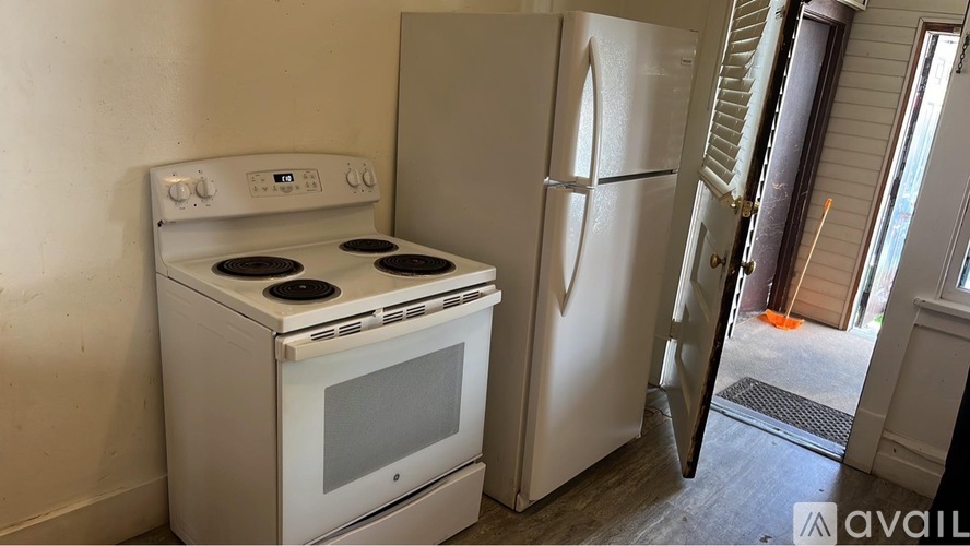 A white stove and refrigerator in a kitchen.