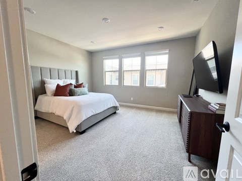 A bedroom with a large bed and a television.