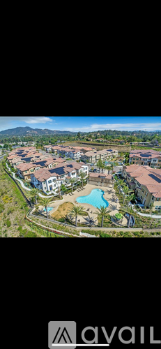 A bird's eye view of a resort with a swimming pool and a mountain in the distance.