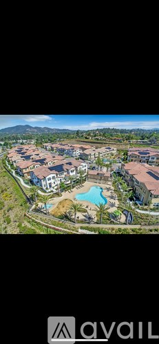 A bird's eye view of a resort with a swimming pool and a mountain in the distance.