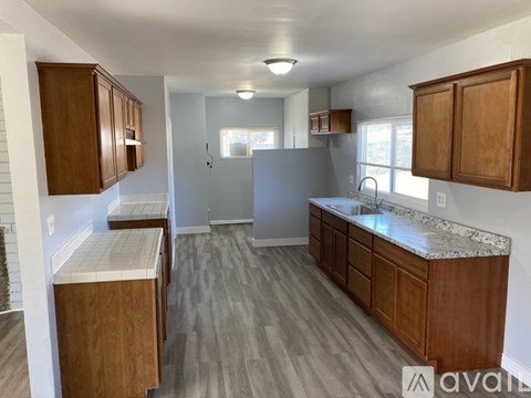 A kitchen with wooden cabinets and a marble countertop.