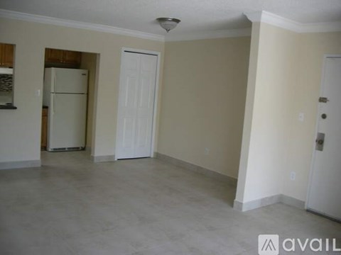A room with a white door and a white fridge.
