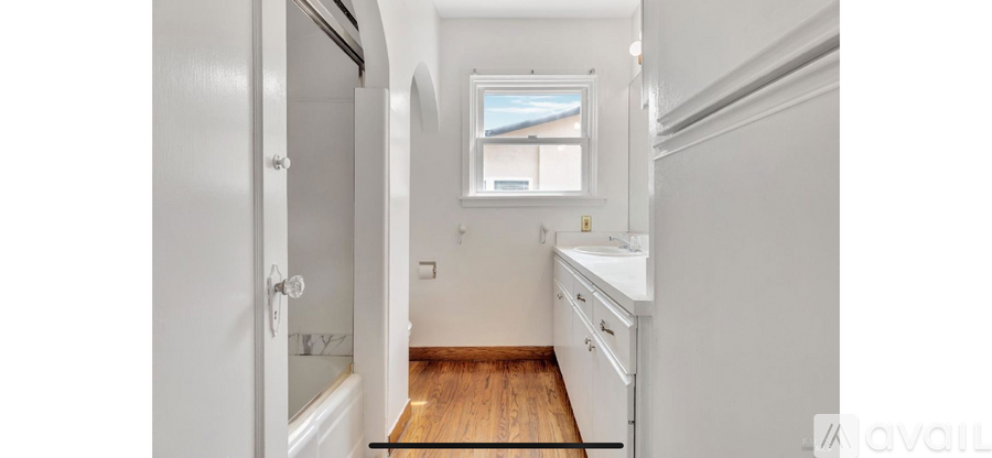 A small white kitchen with a window above the sink.