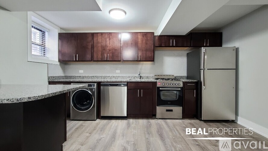 A kitchen with brown cabinets and a black countertop is available for rent.