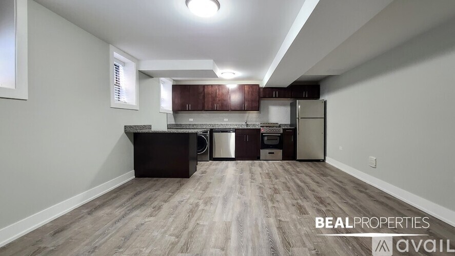 A kitchen area with a refrigerator, sink, and cabinets.