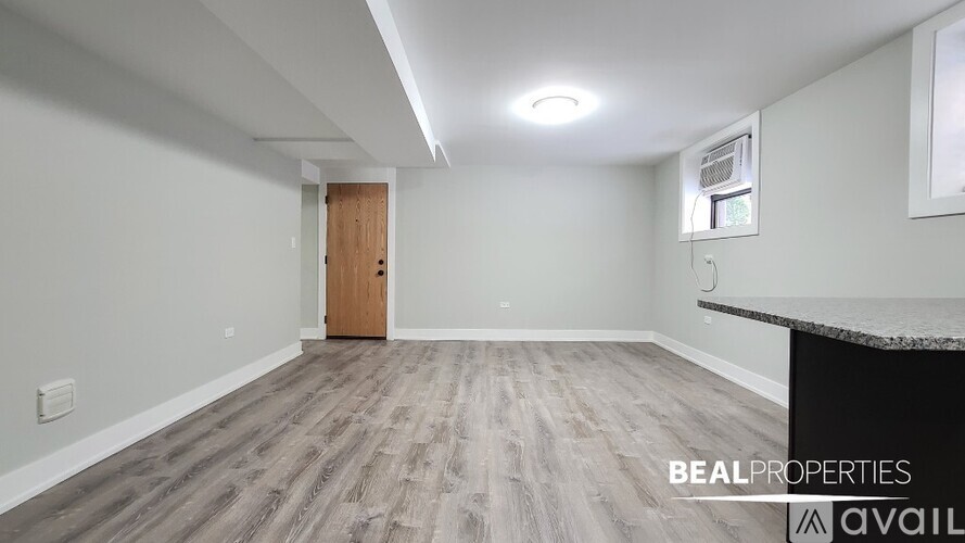 A spacious room with a wooden door and a counter on the right side.