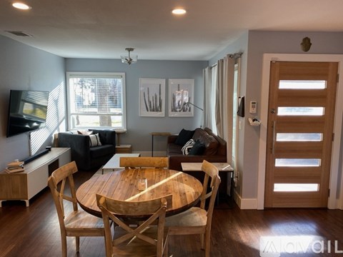 A dining room with a wooden table and chairs.