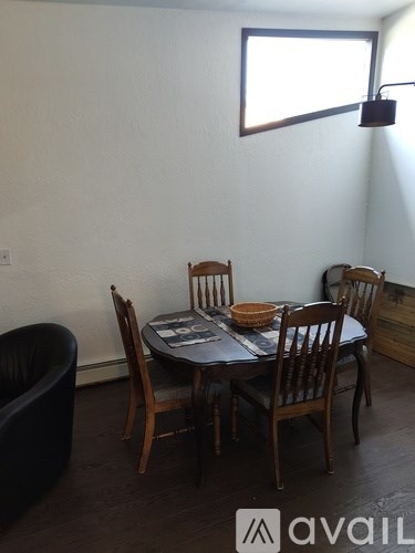 A dining room with a table and chairs.