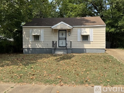 A small house with a black door and white shutters is for sale.