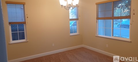 A room with two windows and a chandelier.