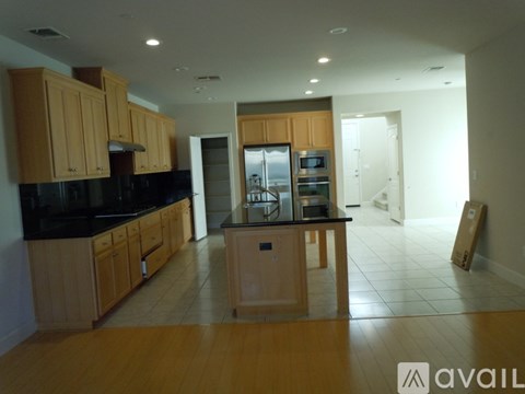 A kitchen with wooden cabinets and black countertops.