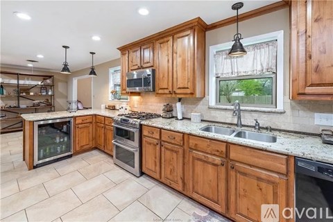 A kitchen with wooden cabinets and granite countertops.