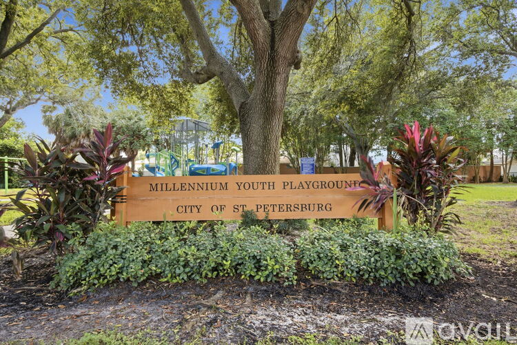 A sign for the Millennium Youth Playground in St. Petersburg is surrounded by greenery.