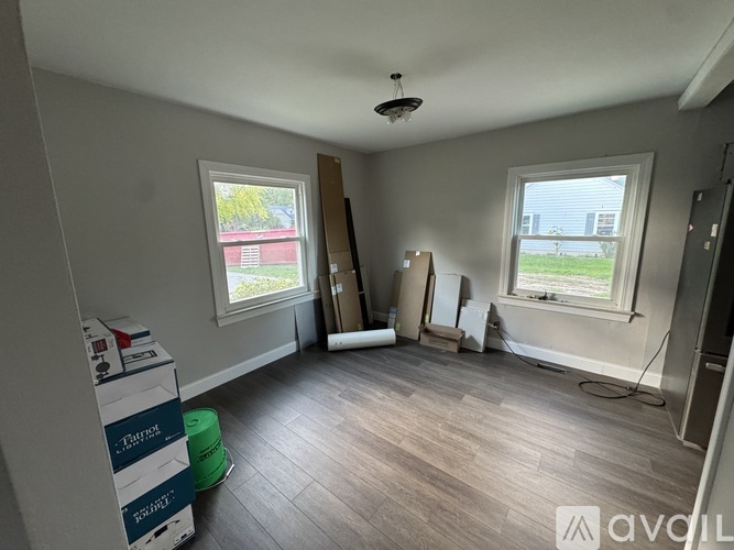 A room with a window and a wooden floor.
