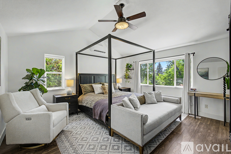 A bedroom with a four poster bed and a chair.