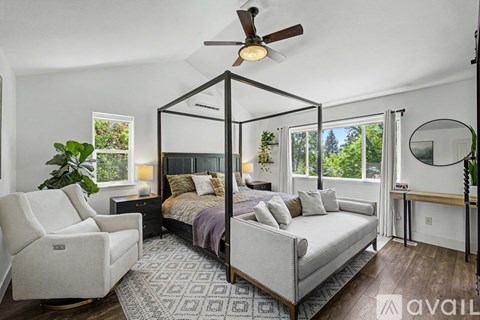 A bedroom with a four poster bed and a chair.