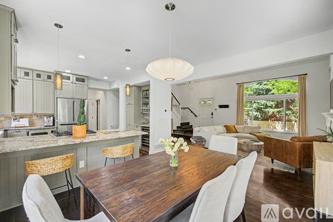 A modern kitchen with a wooden table and chairs.
