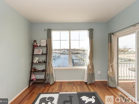 A room with a window overlooking a deck and a shelf with stuffed animals.