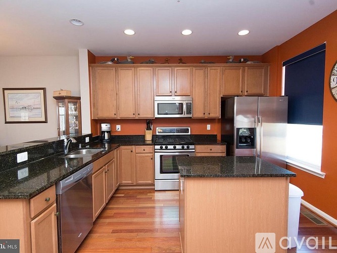 A kitchen with wooden cabinets and granite countertops.