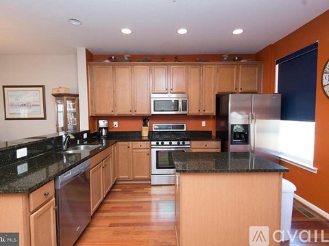 A kitchen with wooden cabinets and granite countertops.