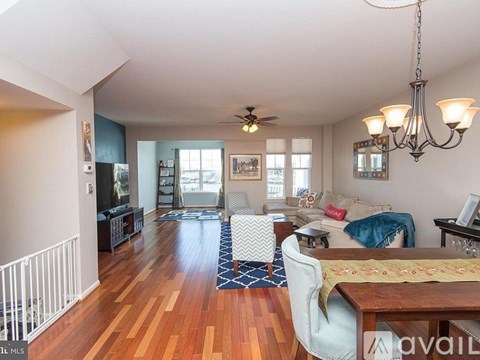 A living room with a white couch and a wooden floor.